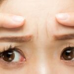 The,Woman,Points,To,The,Crease,Between,Her,Eyebrows.