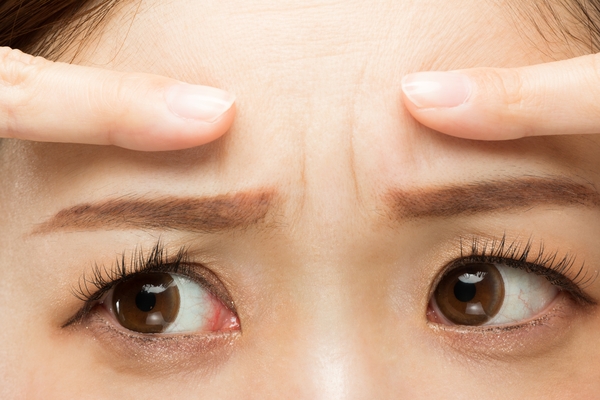 The,Woman,Points,To,The,Crease,Between,Her,Eyebrows.